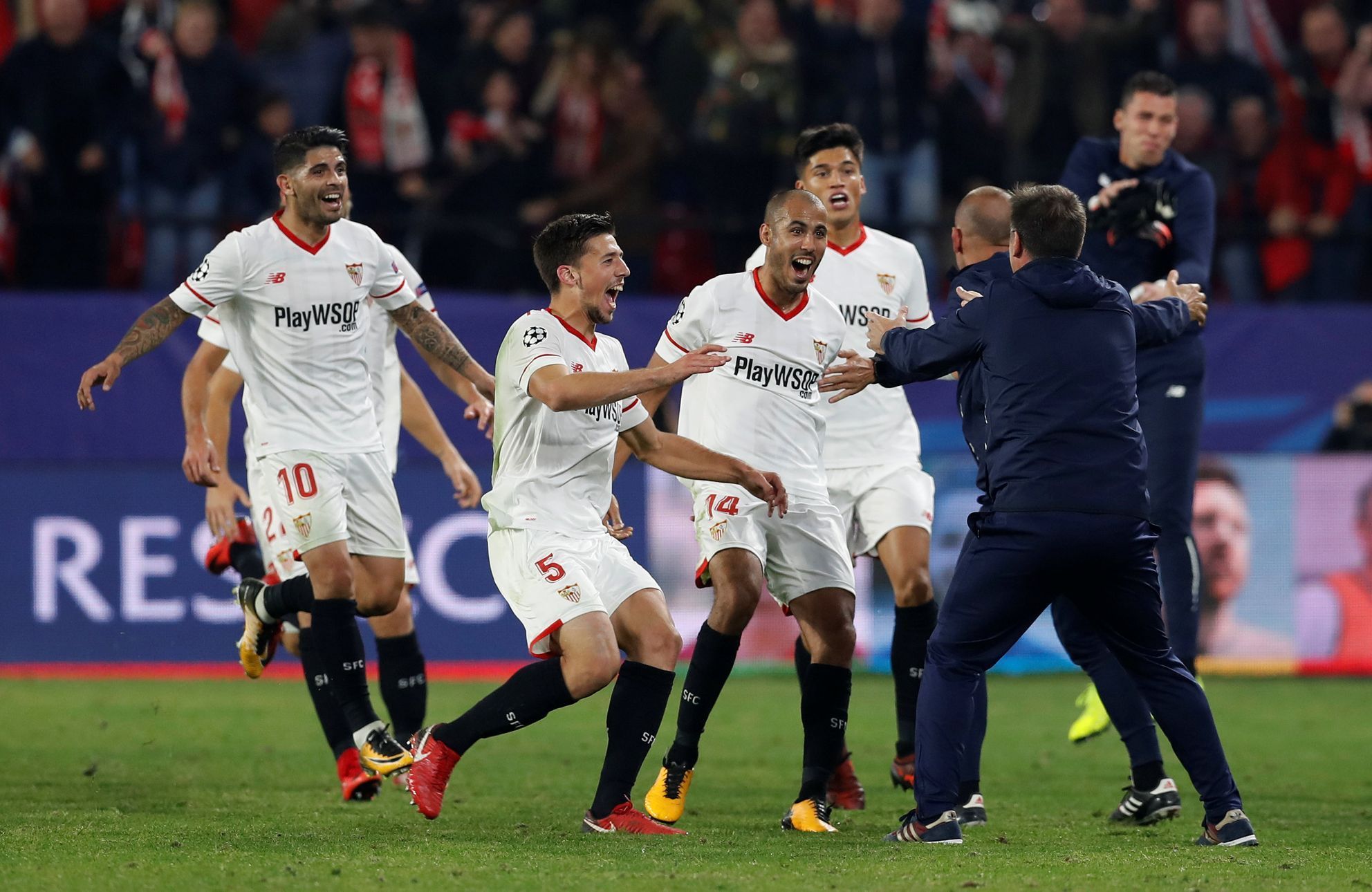 Fotbalisté Sevilly se běží podělit s trenérem Eduardem Berizzem o radost z gólu proti Liverpoolu