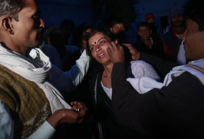 Relatives of a devotee who is believed to be possessed by evil spirits take off her jewellery before performing rituals at Guru Deoji Maharaj temple during a ghost fair at Malajpur village in Betul district in the central Indian state of Madhya Pradesh January 26, 2013. People from across India come to this fair to be exorcised of �evil spirits�. They are usually brought by relatives and they are most often women. The exorcism involves running around the temple courtyard to make the 'ghost' weak then being beaten by a priest with a broom. Picture taken January 26, 2013. REUTERS/Danish Siddiqui (INDIA - Tags: SOCIETY RELIGION) ATTENTION EDITORS: PICTURE 16 OF 24 FOR PACKAGE 'INDIAN GHOSTBUSTERS' SEARCH 'INDIA GHOST' FOR ALL IMAGES Published: Úno. 5, 2013, 5:10 dop.