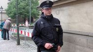 Policista si všiml ruchu, přemýšlí komu má zatelefonovat.