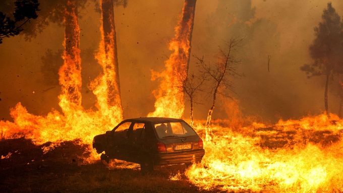 Hořící auto během lesního požáru v obci Meda v Portugalsku, 15. srpna 2025.