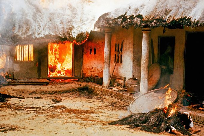 Neidentifikovaná těla u hořícího domu ve vesnici My Lai ve Vietnamu. Fotografie z 16. března roku 1968.