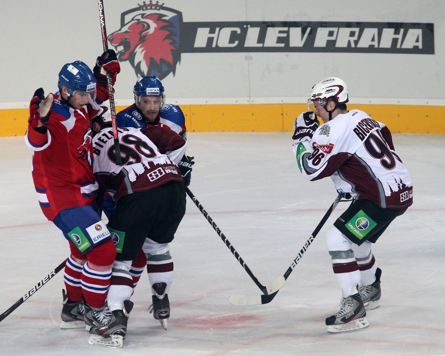 Hokejisté Elvijs Biezais (uprostřed) a Maris Bicevskis (vpravo) dotírají na české hráče v utkání KHL 2012/13 mezi Lvem Praha s Dinamem Riga .