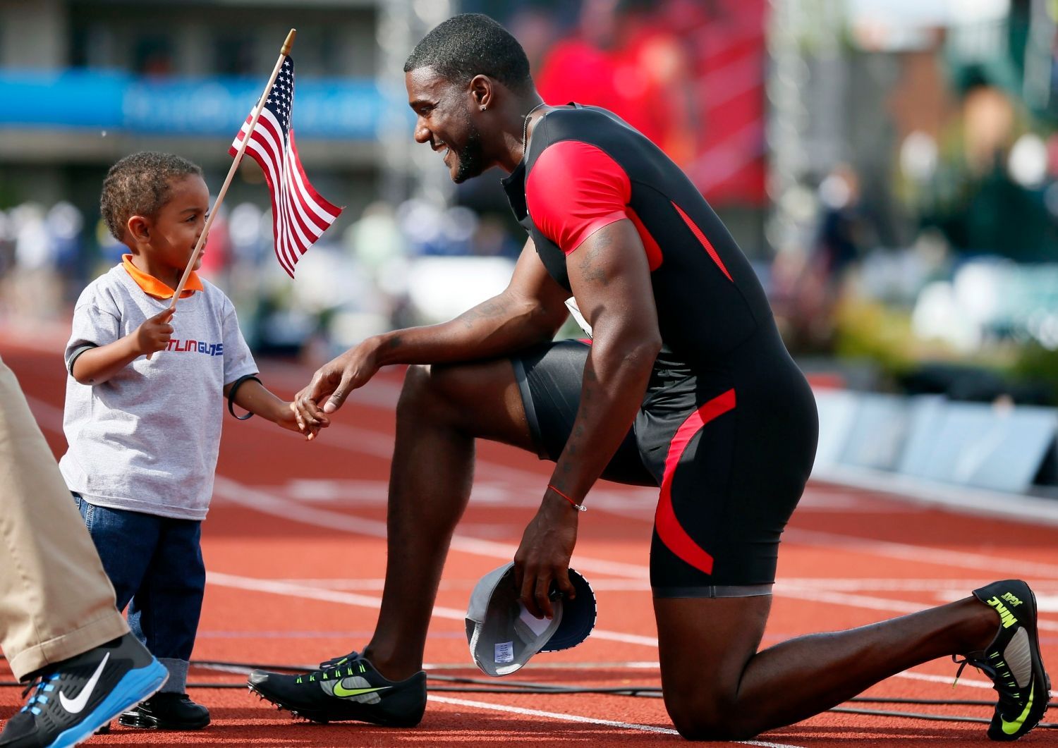 Sprinter Justin Gatlin slaví vítězství v závodu na 100 metrů během americké kvalifikace v Eugene 2012 se synem Jaceem.