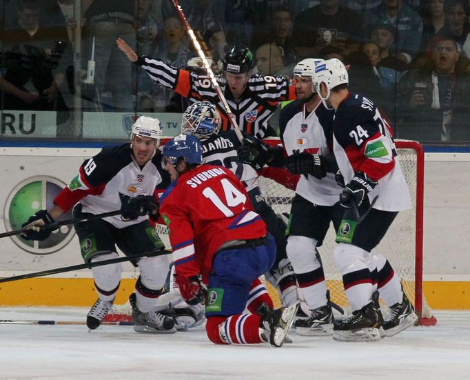 Hokejista Lva Praha Jaroslav Svoboda před Michalem Miklíkem, Jaroslavem Jánusem a Ivanem Švarným (zleva) v utkání KHL 2012/13 proti Slovanu Bratislava.