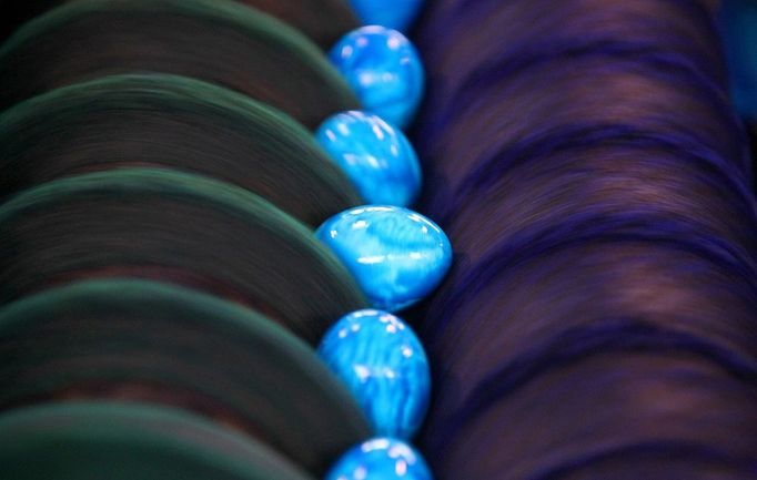 Eggs roll on a conveyor belt through dye rollers in the Beham egg dye-works in Thannhausen, Germany, 30 March 2012. Its peak season at the dyeworks shortly before Easter. Around 180,000 eggs are boiled and dyed here daily. Photo: Karl-Josef Hildenbrand