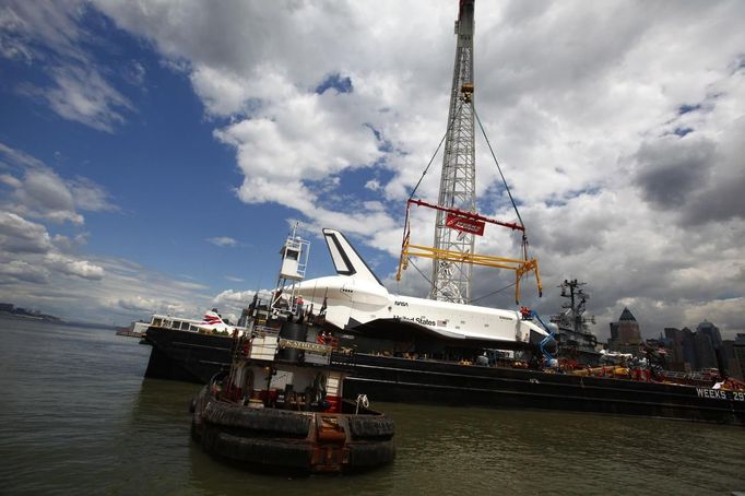 Crew bring a crane into place to hoist the Space Shuttle Enterprise onto the deck of the Intrepid Sea, Air and Space Museum in New York June 6, 2012. REUTERS/Eric Thayer (UNITED STATES - Tags: SCIENCE TECHNOLOGY TRANSPORT) Published: Čer. 6, 2012, 6:17 odp.