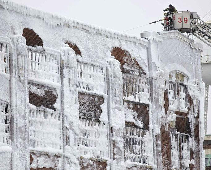 Firefighters spray down hot spots on an ice covered warehouse that caught fire Tuesday night in Chicago January 23, 2013. Fire department officials said it is the biggest fire the department has had to battle in years and one-third of all Chicago firefighters were on the scene at one point or another trying to put out the flames. An Arctic blast continues to gripped the U.S. Midwest and Northeast Wednesday, with at least three deaths linked to the frigid weather, and fierce winds made some locations feel as cold as 50 degrees below zero Fahrenheit. (minus 46 degrees Celsius) REUTERS/John Gress (UNITED STATES - Tags: DISASTER ENVIRONMENT) Published: Led. 23, 2013, 4:59 odp.