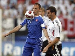 Slovenského útočníka Roberta Vitteka (v modrém) se snaží obrat o míč Němec Christoph Metzelder.