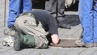 Sticking his head in all the manholes around the Hradčanské Square - that is a job of a fireworker clearing the area of possible bombs.
