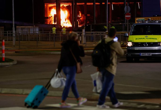 People leave as emergency services respond to a fire in Terminal Car Park 2 at London Luton airport in Luton, Britain, October 11, 2023.  REUTERS/Peter Cziborra