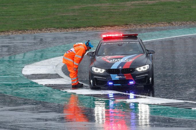 Traťový komisař hovoří s posádkou safery car v deštivém Silverstonu.