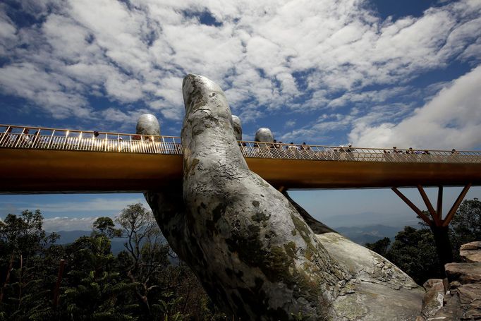 Obří ruka podpírá na kopci Ba Na v nadmořské výšce 1000 metrů nad mořem lávku nazvanou Gold Bridge v blízkosti města Danang ve Vietnamu.