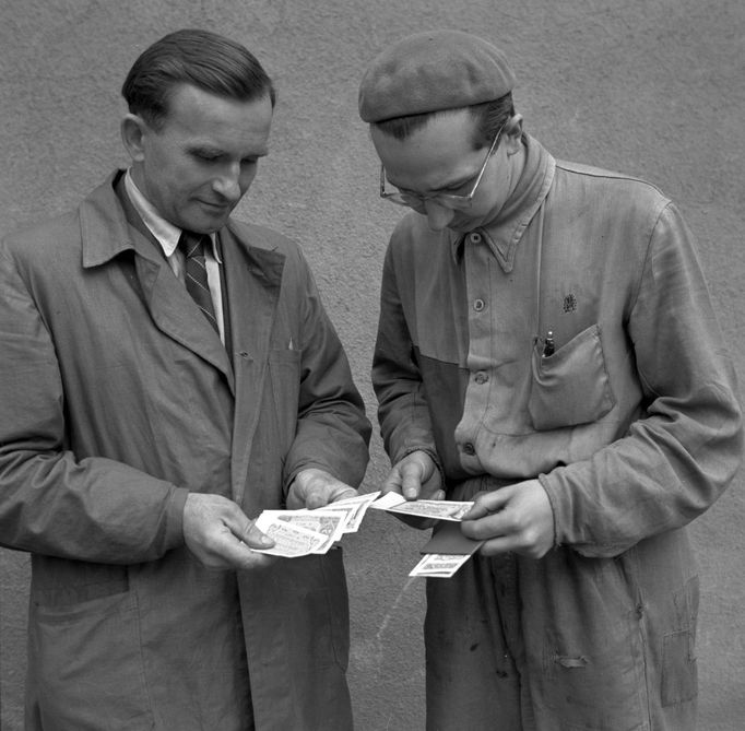 Výměnné středisko v pražské Tesle - Hloubětín. Dělníci si prohlížejí nové peníze po zavedení měnové reformy v roce 1953