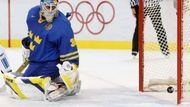 Švédský gólman Lundquist sleduje puk mířící do jeho klece v olympijském finále.