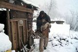 Muž drží svou dceru, když prochází sněhem nedaleko vesnice Poder Chanasi, asi 25 km východně od Muzaffarabádu.