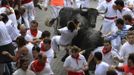 A runner, identified by a Navarran government spokesperson as a 21-year-old Japanese man from Ikeda, is lifted by his scarf onto the horns of a Dolores Aguirre fighting bull on the the first day of the running of the bulls in Pamplona July 7 2012. The man was dragged for approximately 50 metres (164 feet) and suffered light back injuries. REUTERS/Vincent West (SPAIN - Tags: ANIMALS SOCIETY) Published: Čec. 7, 2012, 9:53 dop.