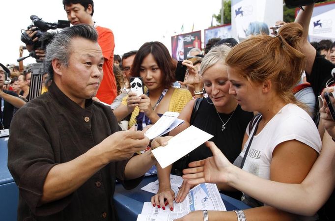 Jihokorejský režisér Kim Ki-duk se podepisuje fanouškům.