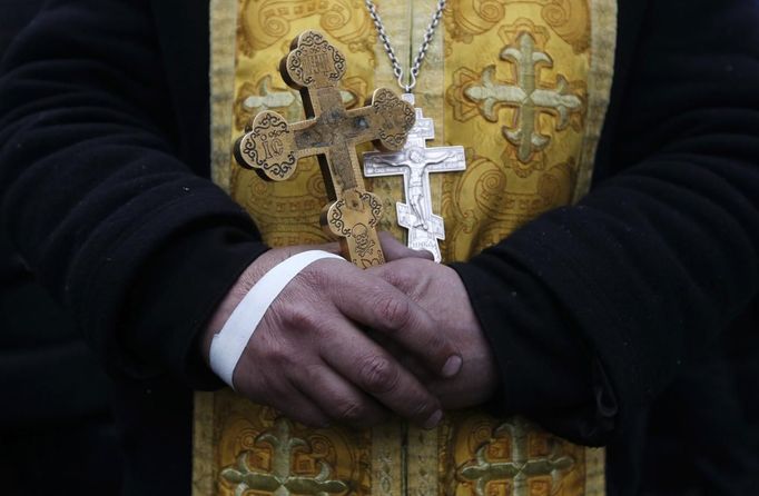 A priest holds a crucifix at a barricade in Kiev February 21, 2014.