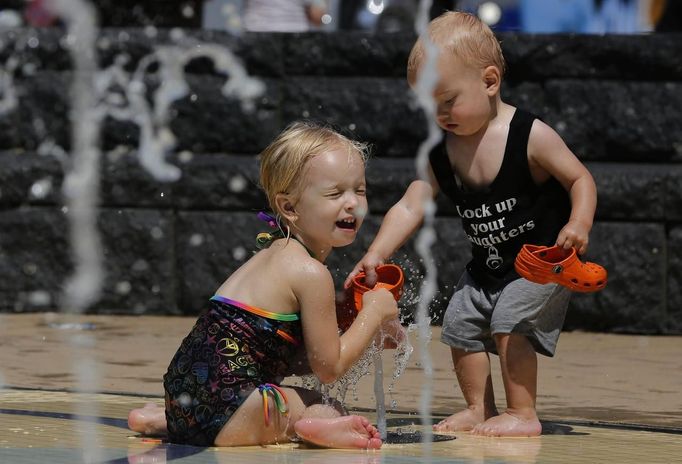 Maddux Lorenzo, 15 months old (R) and his sister, Sam, 3 years old, from Chicago, play in a water fountain to beat the heat gripping the nation's capital while in the Capital Heights neighborhood of Washington, July 2, 2012. REUTERS/Larry Downing (UNITED STATES - Tags: SOCIETY ENVIRONMENT) Published: Čec. 2, 2012, 8:58 odp.