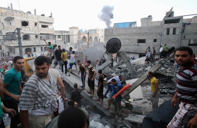 Palestinci troskách hledají těla obětí po izraelském raketovém náletu v Rafah v jižní části Pásma Gazy.