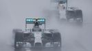 Mercedes Formula One driver Nico Rosberg of Germany leads team mate Lewis Hamilton of Britain behind a safety car (unseen) as they start the first lap of the rain-affecte