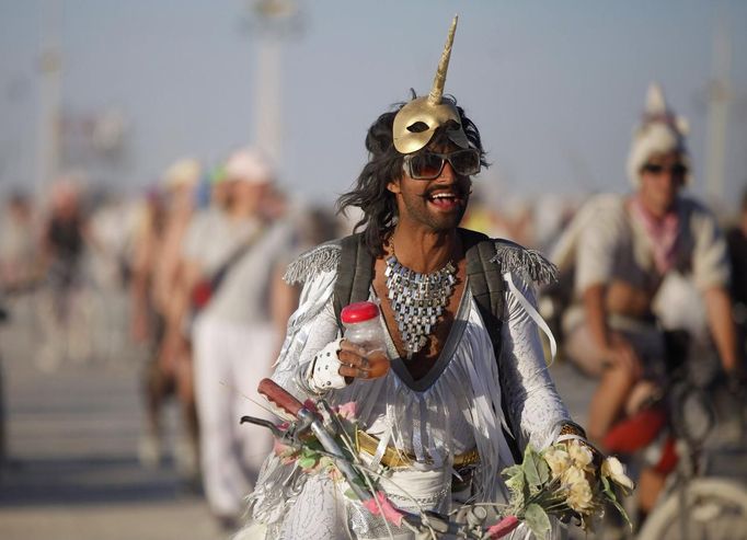 A man of the playa name "Shaft" rides his bicycle in the Unicorn Stampede during the Burning Man 2012 "Fertility 2.0" arts and music festival in the Black Rock Desert of Nevada August 29, 2012. More than 60,000 people from all over the world have gathered at the sold out festival, which is celebrating its 26th year, to spend a week in the remote desert cut off from much of the outside world to experience art, music and the unique community that develops.