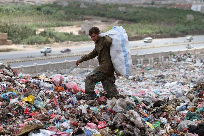 A boy collects recyclable items at a garbage disposal site near Sanaa