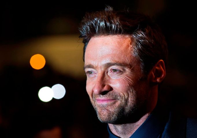 Hugh Jackman poses with fans as he arrives for the "Prisoners