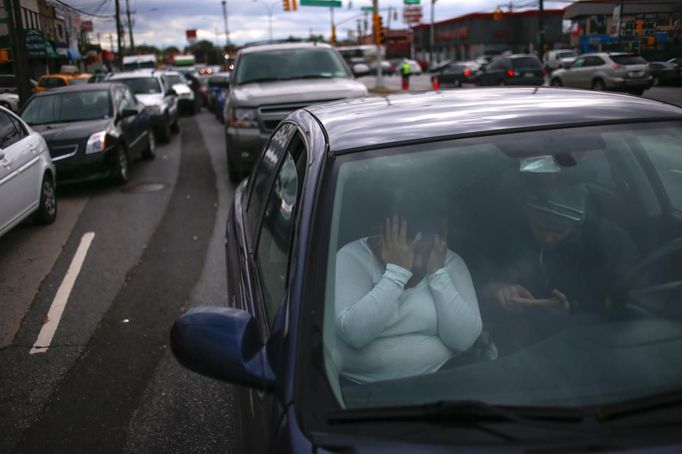 A woman covers her face in frustration while waiting for hours in line to get fuel outside at a gas station in the New York City borough of Queens on November 1, 2012. A fuel supply crisis stalling the New York City area's recovery from Hurricane Sandy and reviving memories of the 1970s gasoline shortages stem from multiple factors, ranging from flooding to power outages to a diesel spill. REUTERS/Adrees Latif (UNITED STATES - Tags: DISASTER ENVIRONMENT ENERGY TPX IMAGES OF THE DAY) Published: Lis. 1, 2012, 8:56 odp.