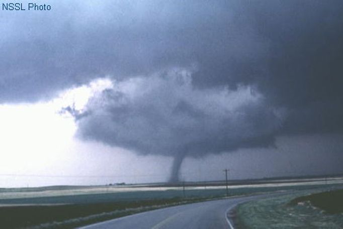 Alfalfa OK, 22 May 1981, looking NNW. A "textbook" tornado extending from the wall cloud of a classic supercell, with a "clear slot" cutting through the cloud base around the near side of the wall cloud. The slot represents part of the occlusion downdraft, an arc of sinking air believed to contribute to tornado development in many cases. The tornado did damage rated at F2.