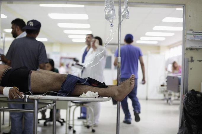 Doctors tend to a man who had a gunshot wound at the emergency ward of a local hospital in San Pedro Sula March 20, 2013. San Pedro Sula, the country's second largest city after Tegucigalpa, has a homicide rate of 169 per 100,000 people and was named the world's most violent city for a second year in a row. Lax laws allow civilians to own up to five personal guns. Arms trafficking has flooded the country with nearly 70% illegal firearms. 83.4% of homicides are by firearms, compared to 60% in the United States. Picture taken March 20, 2013. REUTERS/Jorge Cabrera (HONDURAS - Tags: CRIME LAW CIVIL UNREST HEALTH) ATTENTION EDITORS: PICTURE 27 OF 39 FOR PACKAGE 'GUN CULTURE - HONDURAS' SEARCH 'HONDURAS GUN' FOR ALL IMAGES Published: Dub. 5, 2013, 11:15 dop.