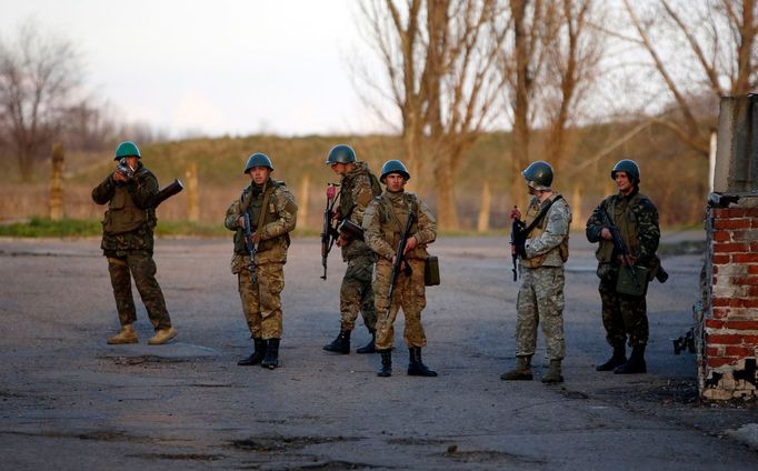 An Ukrainian soldier (L) aims his rifle at pro-Russia protesters gathered in front of an Ukrainian airbase in Kramatorsk, in eastern Ukraine April 15, 2014.