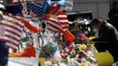 A man kneels down to place a message on a makeshift memorial after observing a moment of silence for the victims of the Boston Marathon bombings marking a week to the day of the bombings at a memorial on Boylston Street in Boston, Massachusetts April 22, 2013. REUTERS/Jessica Rinaldi (UNITED STATES - Tags: CRIME LAW CIVIL UNREST) Published: Dub. 22, 2013, 8:01 odp.