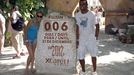 Tourists get their picture taken next to a slab of stone counting down the days until Dec. 21, 2012 at the Xcaret theme park in Playa del Carmen, Mexico, Saturday, Dec. 15, 2012. Amid a worldwide frenzy of advertisers and new-agers preparing for a Maya apocalypse, one group is approaching Dec. 21 with calm and equanimity calm: the people whose ancestors supposedly made the prediction in the first place. Mexico's 800,000 Mayas are not the sinister, secretive, apocalypse-obsessed race they've been made out to be. (AP Photo/Israel Leal)