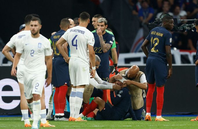 Útočníkovi Francie Antoinu Griezmannovi ovazují lékaři hlavu poté, co ho do ní kopl soupeř z Řecka. Francie díky tomu kopala penaltu a rozhodla o výhře