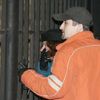 Příbuzní obětí nahlížejí přes plot do dvora nemocnice, kde při požáru zahynulo přes čtyřicet lidí