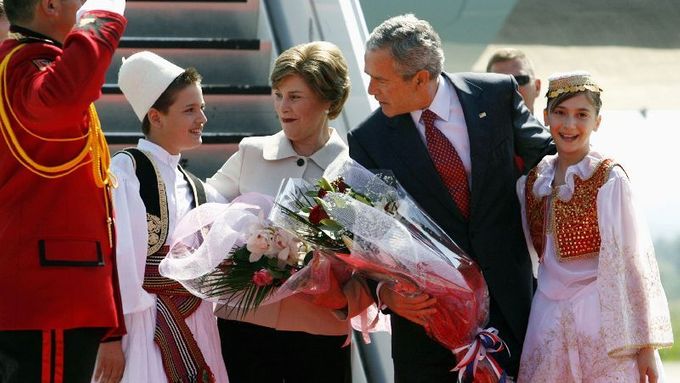 Bushovi se dostalo popmézního uvítání na tiranském letišti. Nechyběl chléb a sůl ani lidové písně a tance.