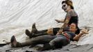 A zombie (top) and a runner go down a water slide at the "Run for Your Lives" 5K obstacle course race in Amesbury, Massachusetts May 5, 2012. Runners face man-made and natural obstacles on the course, while being chased by zombies, who try to take "health" flags off the runners belts. REUTERS/Brian Snyder (UNITED STATES - Tags: SPORT SOCIETY) Published: Kvě. 5, 2012, 11:28 odp.