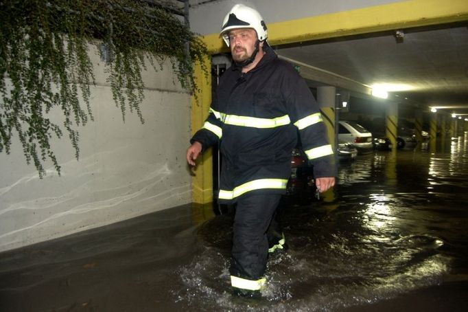 Hasič se brodí místy, kudy v Hradci obvykle projíždějí auta. Bouřka zatopila garáže v Jungmannově ulici.