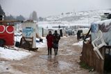 Dvě ženy ze syrské Rakky procházejí uprchlickým táborem v libanonském údolí Bikáa, který se po páteční sněhové bouři ocitl pod sněhem.
