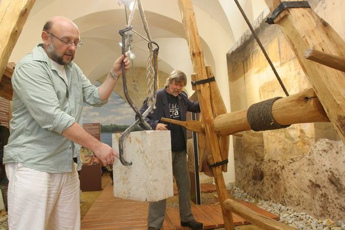 Autor výstavy Petr Ševců a konstruktér středověkých stavebních strojů Petr Růžička předvádějí, jak fungoval stavební jeřáb. Středověké kvádry lze poznat podle otvorů na bocích. V současnosti jich je v mostě asi třetina.