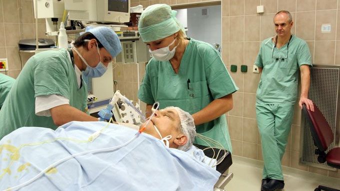 3:18 Po osmnácti hodinách služby a pěti hodinách na sále pozoruje doktor Adamec své kolegy, jak připravují pacienta k převozu na jednotku intenzivní péče.