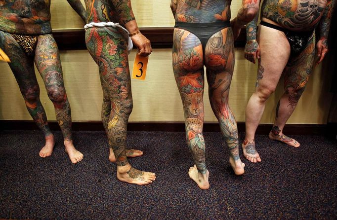 Male full-body tattoo contestants including Jeff Bitting (R) wait in line to be judged at the National Tattoo Association Convention in Cincinnati, Ohio April 13, 2012. In his 33 years of getting tattoos, Bitting says he has had about 500 hours of work and will complete his other leg in his bid to win more full-body contests. Picture taken April 13, 2012. REUTERS/Larry Downing (UNITED STATES - Tags: SOCIETY) ATTENTION EDITORS PICTURE 17 OF 31 FOR PACKAGE 'ADDICTED TO THE NEEDLE' TO FIND ALL PICTURES SEARCH 'ADDICTED NEEDLE' Published: Čer. 29, 2012, 12:59 odp.