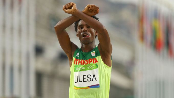 Stříbrný maratonský běžec Feyisa Lilesa protestuje v cíli olympijského maratonu proti násilí páchanému v Etiopii na jeho kmenu.