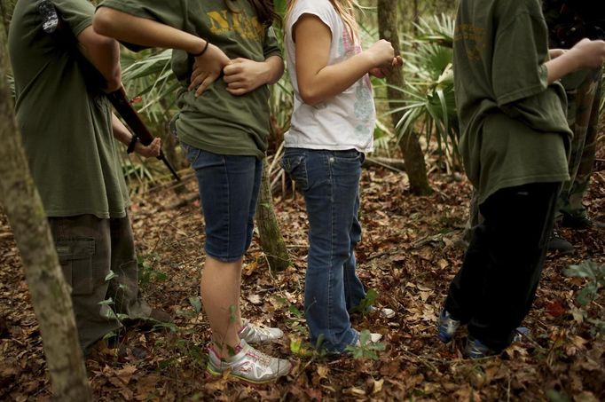 A group of children, all members of the North Florida Survival Group, walk through a wooded area during a field training exercise in Old Town, Florida, December 8, 2012. The group trains children and adults alike to handle weapons and survive in the wild. The group passionately supports the right of U.S. citizens to bear arms and its website states that it aims to teach "patriots to survive in order to protect and defend our Constitution against all enemy threats". Picture taken December 8, 2013. REUTERS/Brian Blanco (UNITED STATES - Tags: SOCIETY POLITICS) ATTENTION EDITORS: PICTURE 8 OF 20 FOR PACKAGE 'TRAINING CHILD SURVIVALISTS' SEARCH 'FLORIDA SURVIVAL' FOR ALL IMAGES Published: Úno. 22, 2013, 1 odp.