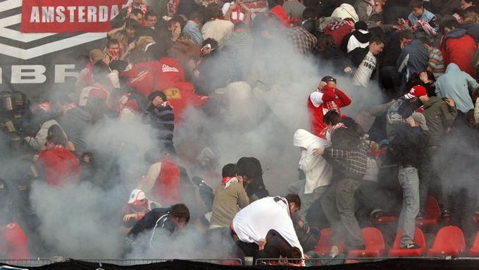 Fans protect themselves from police petards used to disperse them