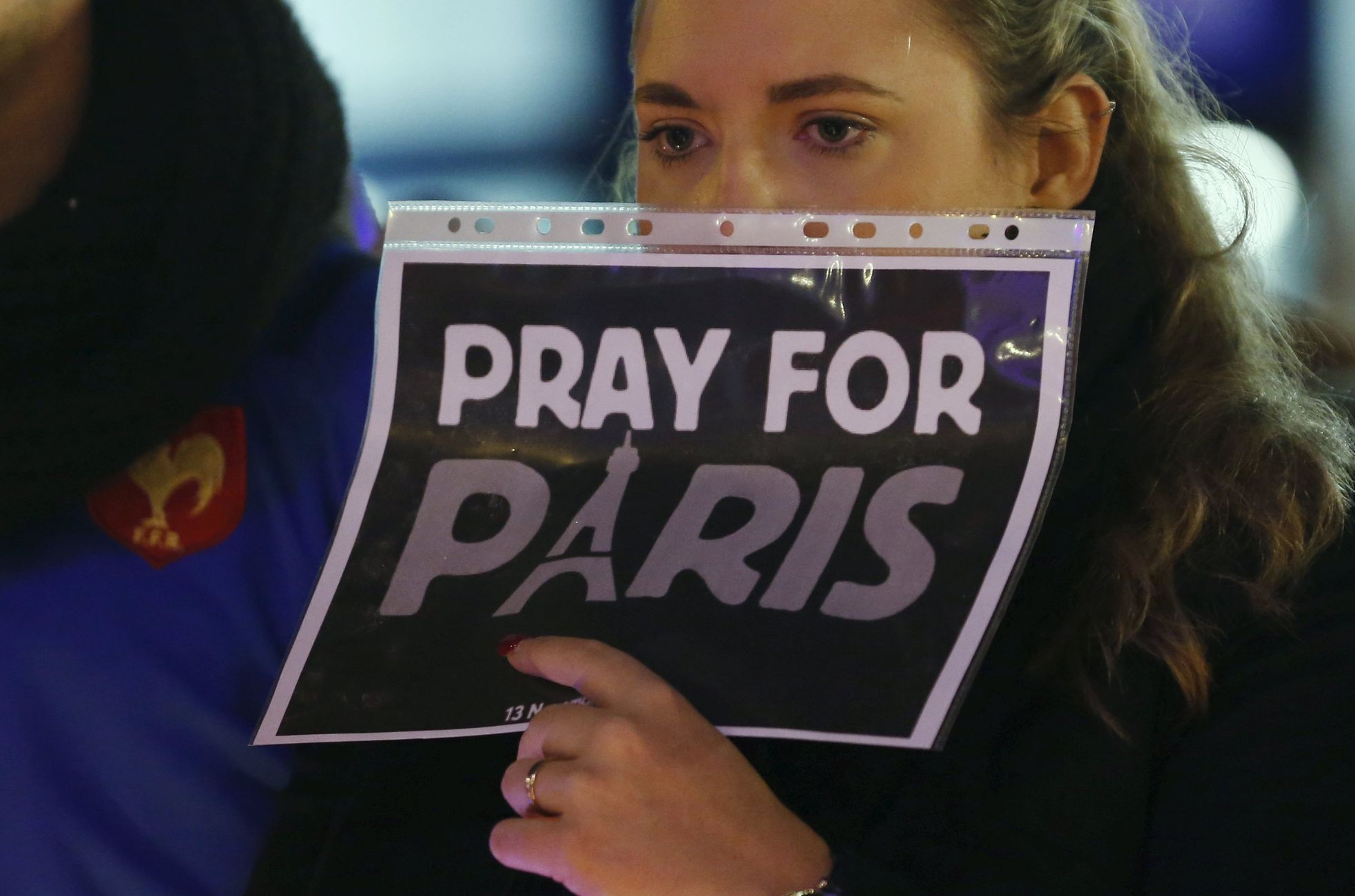 A woman holds a sign during a ceremony in solidarity with the victims the day after a series of deadly attacks in the French capital of Paris, in Lausanne