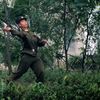 Severokorejský voják háže kameny na fotografa ve městě Sinujiu na severokorejské straně řeky Ja-lu, která odděluje Severní Koreu od Číny