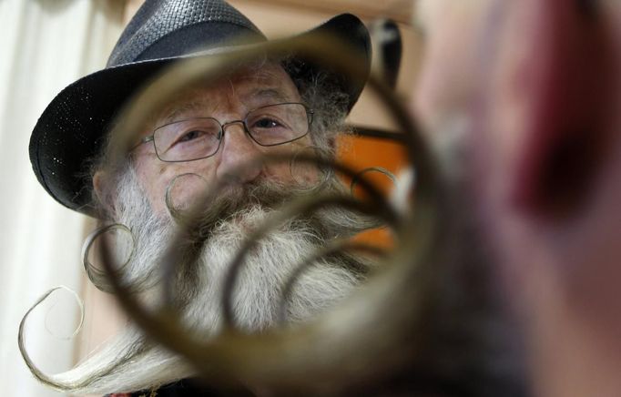 A participant is seen through the moustache of a fellow competitor as he helps him to get ready for the 2012 European Beard and Moustache Championships in Wittersdorf near Mulhouse, Eastern France, September 22, 2012. More than a hundred participants competed in the first European Beard and Moustache Championships organized in France. REUTERS/Vincent Kessler (FRANCE - Tags: SOCIETY) Published: Zář. 22, 2012, 7:25 odp.