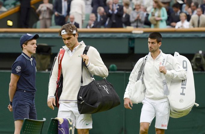 Švýcarský tenista Roger Federer a Srb Novak Djokovič nastupují ke společnému utkání v semifinále Wimbledonu 2012.